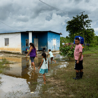 WFP's first response to a climate emergency in Venezuela. A family is walking in front of their homes which is ruined due to flood. Photo: WFP/Marianela González