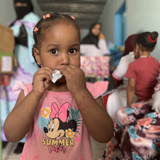 Refugee girl enjoying her nutrition product. Photo: WFP/Ayoub Boudjella 