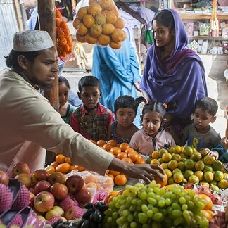Woman shopping with her kids at a bazaar. Photo: WFP/Wahid Adnan