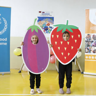 Two schoolchildren in Armenia showing the cartoons shaped as strawberry and eggplant